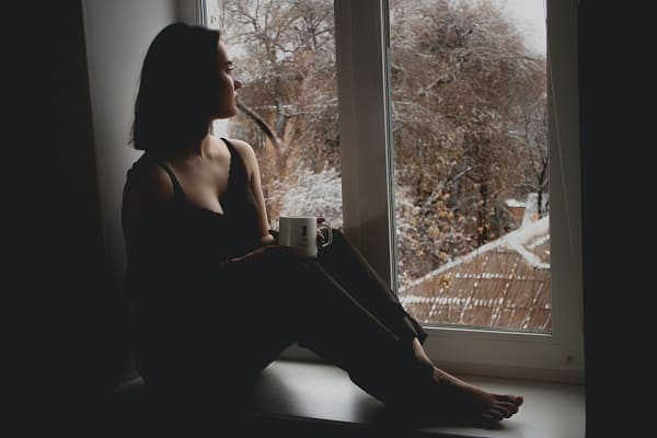 hình ảnh cô gái buồn ngồi bên cửa sổ